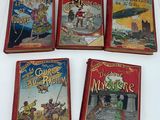 four children ' s books are lined up on a white surface