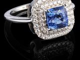 gros plan d'une bague en saphir bleu et diamant sur une surface noire