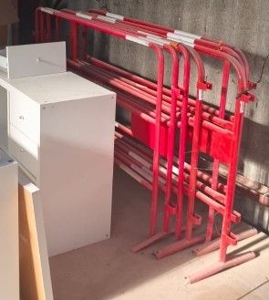 une borne d'incendie rouge posée à côté d'une pile de tuyaux rouges