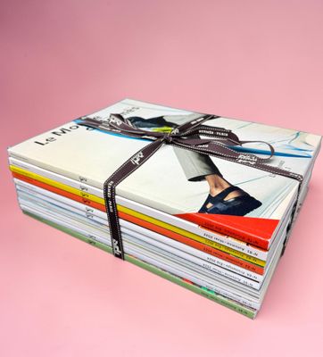 une pile de magazines entourée d'un ruban sur fond rose