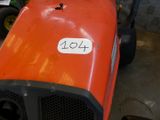 un tracteur orange portant un numéro, dans un garage
