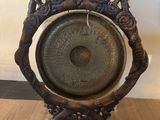 a metal gong on a stand on a wooden floor