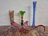 trois vases en verre posés sur une table l'un à côté de l'autre