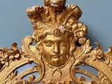 un miroir doré avec un visage au milieu