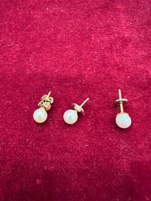 une paire de boucles d'oreilles en perles posées sur un fond de velours rouge