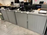 a man that is standing in front of a desk in an office