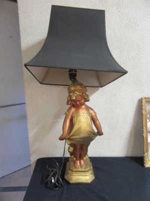 a lamp that has a little girl on it on a table