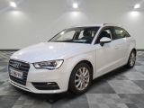 L'Audi blanche est garée dans une grande pièce au sol carrelé en damier.