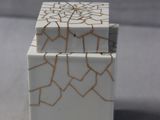 a small white box with a cracky design on it