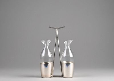 pair of silver vases on a white surface with a gray background