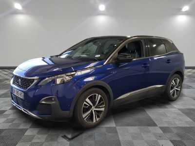 une voiture bleue est garée dans une pièce au sol à carreaux