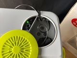 a small yellow fan sitting on top of a white refrigerator