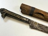 two different types of knives on a white surface