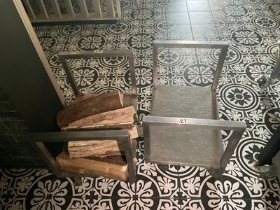 une pile de bois de chauffage posée par terre dans une cuisine