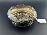une assiette ancienne en argent avec une étiquette sur un fond noir