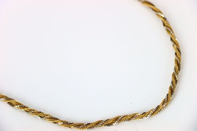 une photo d'un collier en or posé sur une assiette blanche