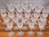 a lot of wine glasses sitting on a wooden table