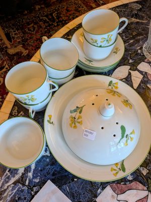 Plusieurs tasses et soucoupes sont posées sur une table en marbre