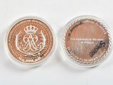 two commemorative coins with a crown on top of them on a white surface