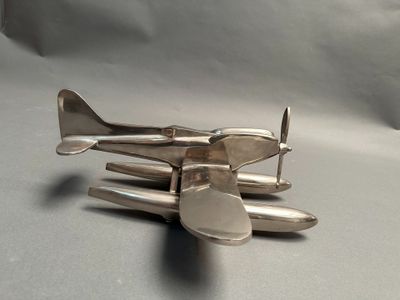 a small silver airplane sitting on top of a table