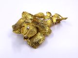 an image of a gold flower brooch on a white background