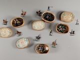 plusieurs figurines miniatures représentant des personnes, disposées dans des bols en bois posés sur une table