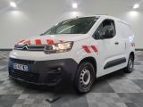 une camionnette Citroën rayée de rouge et de blanc, garée dans un garage
