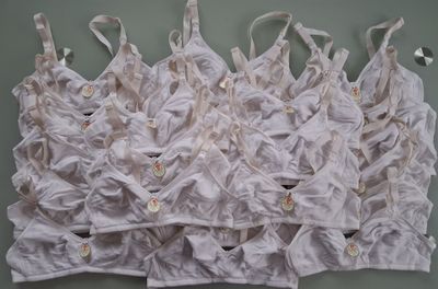 de nombreux brassières blanches accrochées les unes à côté des autres sur un mur