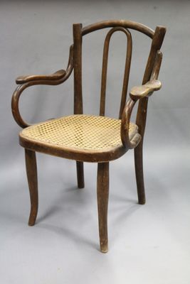 FAUTEUIL d'enfant en bois courbé et assise cannée.