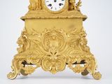 a gold clock that is sitting on top of a table