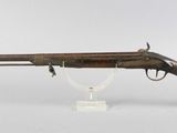 an old rifle with a wooden barrel and a glass stand