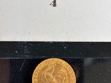 un gros plan d'une pièce d'or dans une boîte posée sur une table