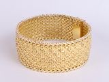 gold woven bracelet with a gold clasp on a white background