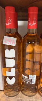trois bouteilles d'alcool posées sur une étagère dans un magasin