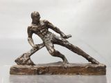statue en bronze représentant un homme tenant une batte de baseball sur une base