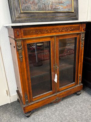 une armoire sur laquelle est posé un tableau, à côté d'une commode