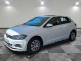 la volkswagen polo blanche est garée dans une pièce au sol à carreaux