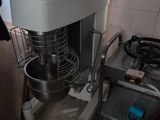 a woman that is standing in a kitchen with a mixer