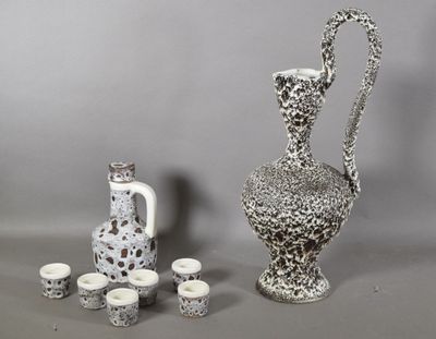 un vase et des tasses blancs et noirs placés les uns à côté des autres
