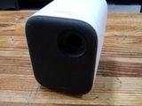 une enceinte blanche et noire posée sur une table en bois