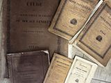 plusieurs vieux livres posés les uns à côté des autres sur un plancher en bois