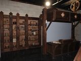 a room with a desk and a book shelf in it