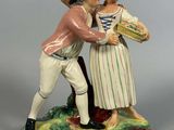 une figurine représentant un homme et une femme tenant un panier