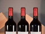 three bottles of red wine sitting on a table
