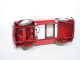 a small red toy train on a white surface