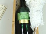 une bouteille de vin dans un coffret en bois à côté d'une bouteille de vin