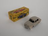 une petite voiture miniature posée à côté d'une boîte sur une table