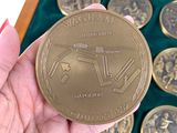 a person holding a gold coin in front of a box