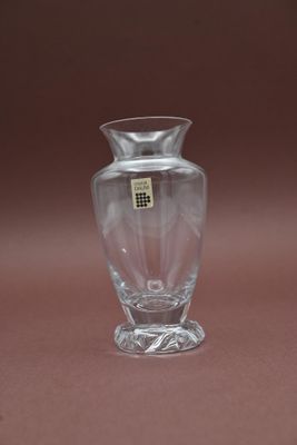 un petit vase en verre muni d'une étiquette, posé sur une table