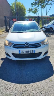 la voiture blanche est garée dans le parking à côté du bâtiment
